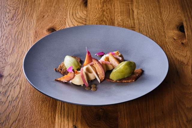 Assiette ardoise avec poire pochée, figues rôties et crème sur fond de chocolat – Restaurant Bistronomique Douai