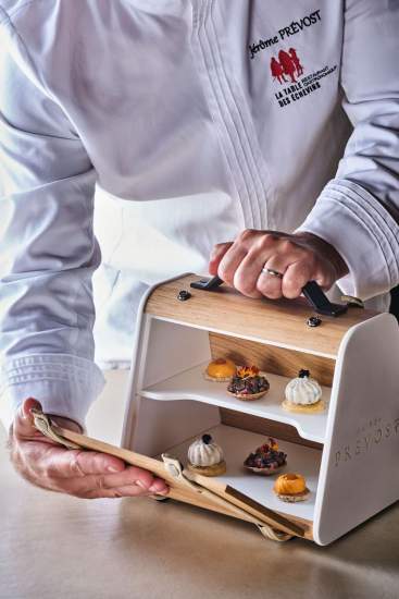 Présentation de mignardises sur présentoir en bois à deux niveaux, service gastronomique – Restaurant Gastronomique Hauts-de-France