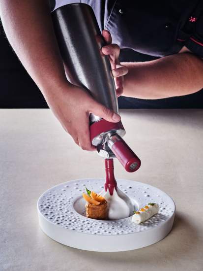 Dressage à la poche à douille d'une crème sur assiette texturée avec mignardises – Restaurant Gastronomique Hauts-de-France