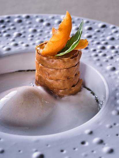 Millefeuille croustillant, quenelle de sorbet et segment d'orange dans une assiette blanche – La Table des Échevins Douai