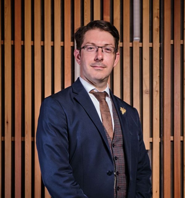 Homme en costume bleu marine, portrait professionnel devant boiserie claire – Maison Prevost Douai