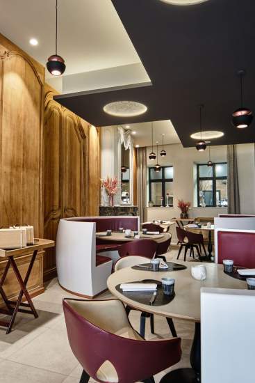 Salle du restaurant avec tables rondes, chaises bordeaux et banquettes, lumière naturelle – Boterzing Douai