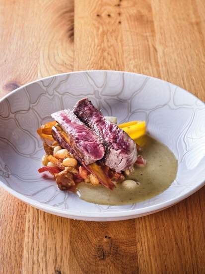 Pièce de viande braisée, légumes et bouillon en assiette creuse texturée – Restaurant gastronomique Douai